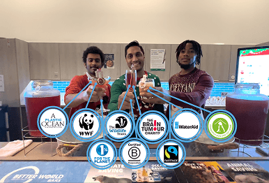 Three professional bartenders smiling and raising sustainable cocktails behind a mobile event bar with overlaid charity logos representing our commitment to supporting vital causes through our ethical supply chain