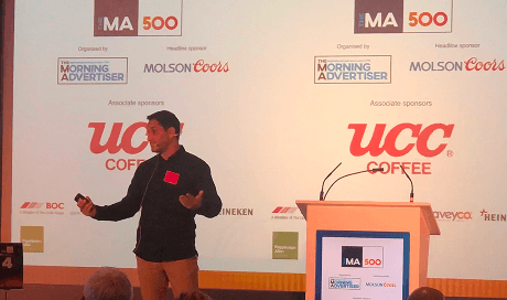 Our founder Randy Rampersad standing on stage delivering a presentation on ethical pub practices to multi chain pub operators at The Morning Advertiser MA500 event