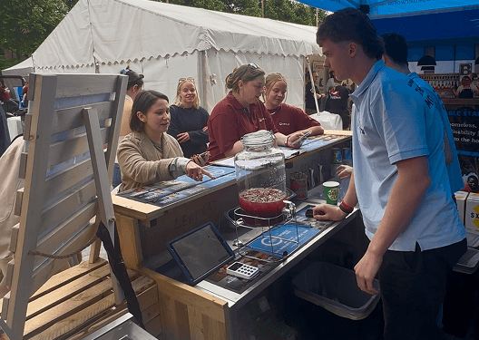 Festival-goers mingling around the premium mobile bar at the Earthfest London festival