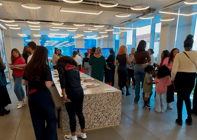 Guests filling Nike's Kings Cross head office around the catering counter during the graduation celebration